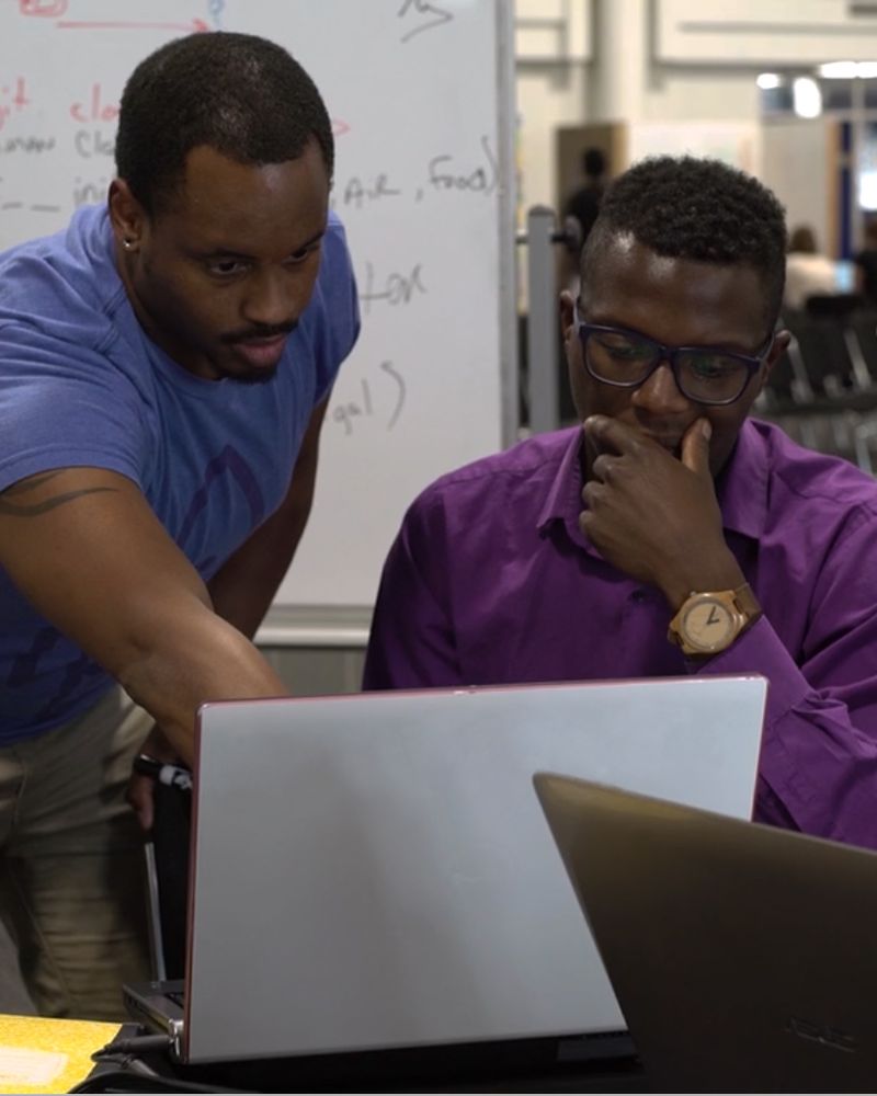 Two LaunchCode learners pair programming at a laptop